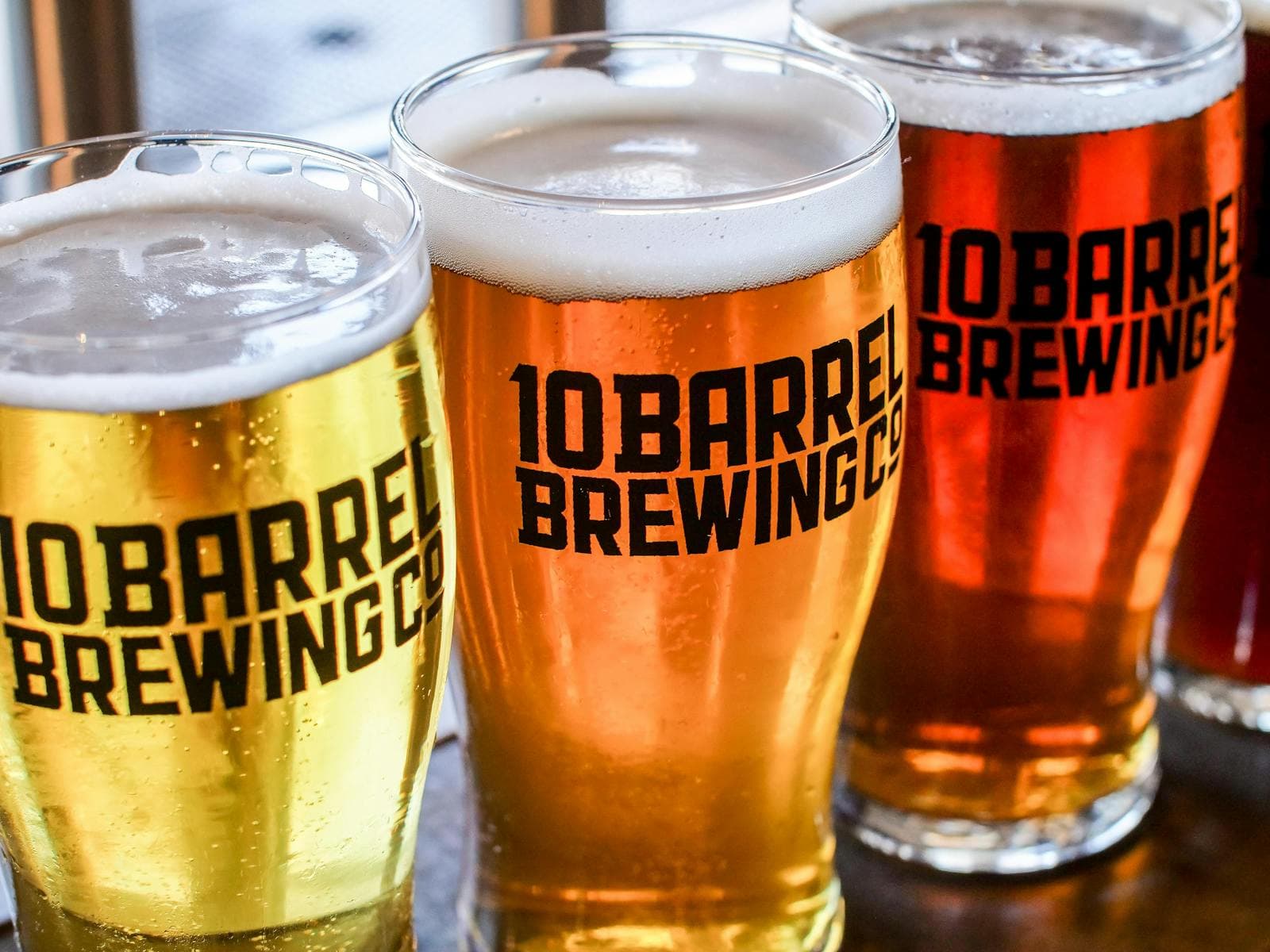A glass beer mug catching warm light on a dark background.